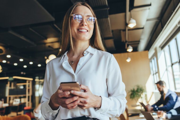 Zamyślona kobieta biznesu z telefonem w coworkingu